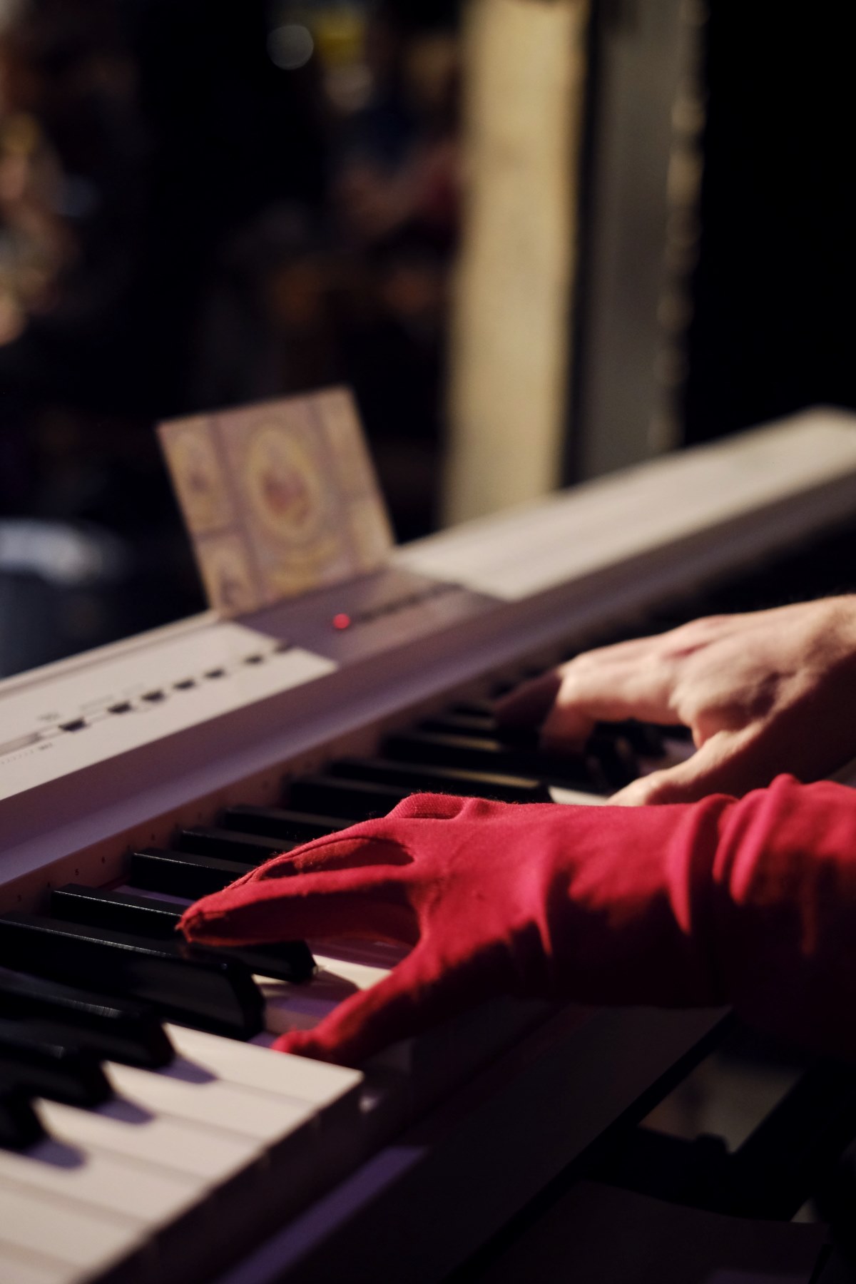 Main gantée rouge sur piano